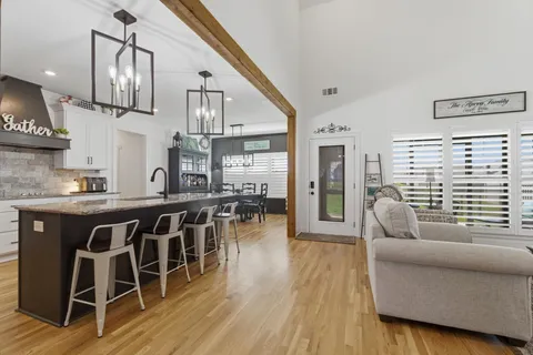 a living room with furniture a dining table and wooden floor