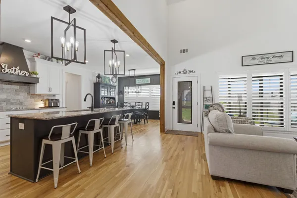 a living room with furniture a dining table and wooden floor