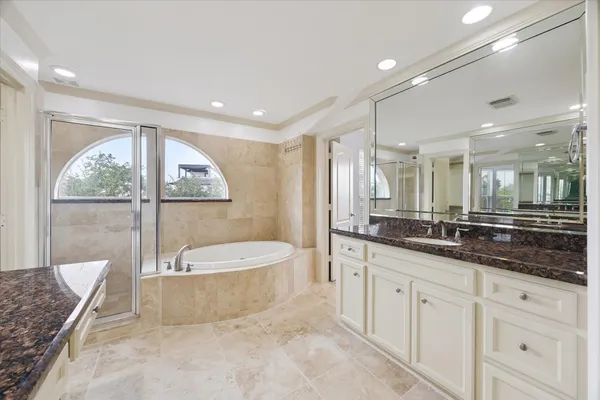 a spacious bathroom with a double vanity sink a mirror and a bathtub