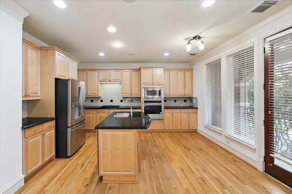 a kitchen with stainless steel appliances granite countertop a refrigerator and a stove top oven