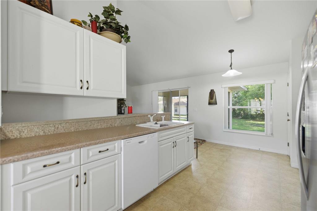 3959 Southwest 129th Street Ocala, FL 34473 - Photo 7 of 27 a kitchen with granite countertop white cabinets and window