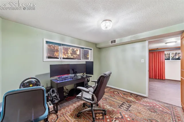 a view of a workspace with furniture and a window