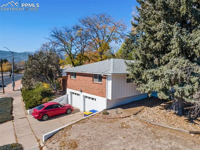 a front view of a house with large trees