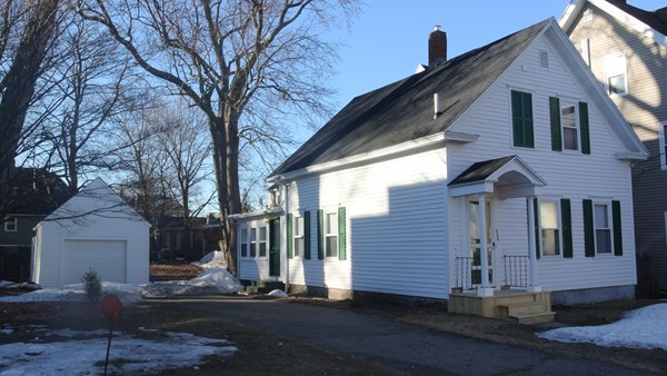 a front view of a house with a tree