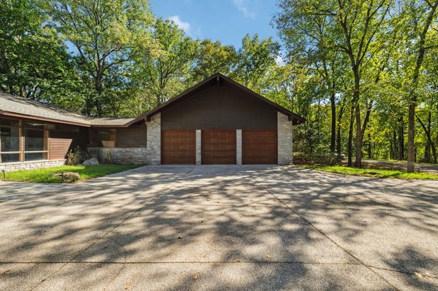 a view of a house with a yard and large tree