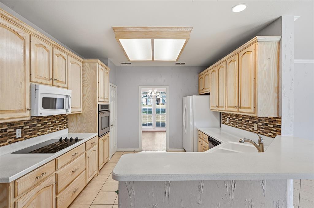 135 Rim Rock Road Aledo, TX 76008 - Photo 11 of 40 a kitchen with granite countertop a stove oven and sink