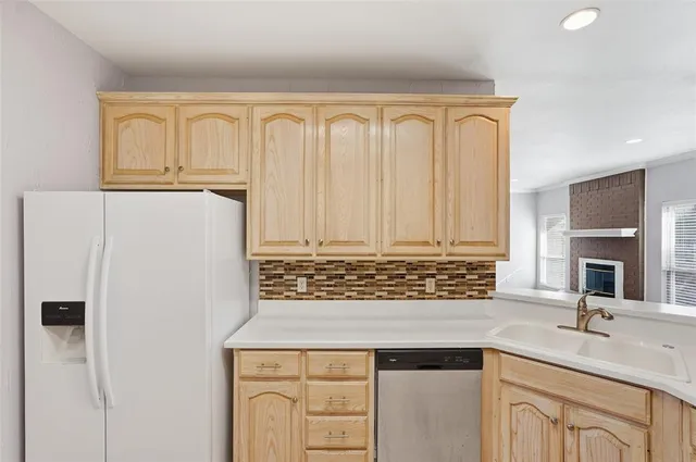 a view of a kitchen with granite countertop a sink and a refrigerator