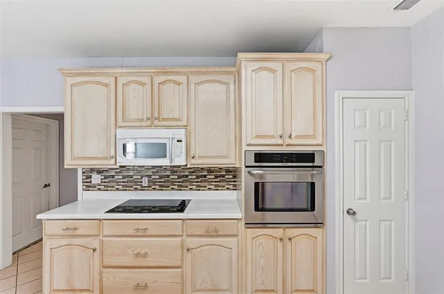 a kitchen with white cabinets and black appliances