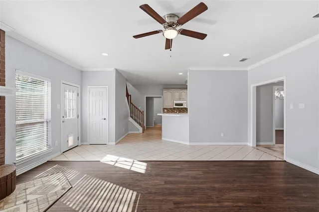 a view of a livingroom with wooden floor and a ceiling fan