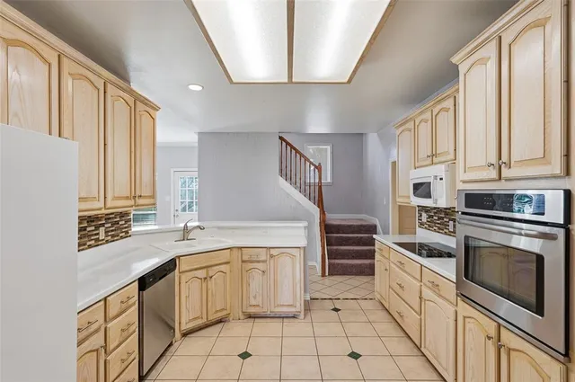 a kitchen with a stove sink and cabinets
