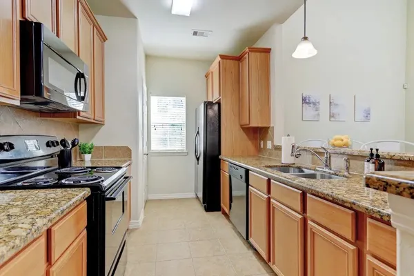 a kitchen with stainless steel appliances a sink stove and refrigerator