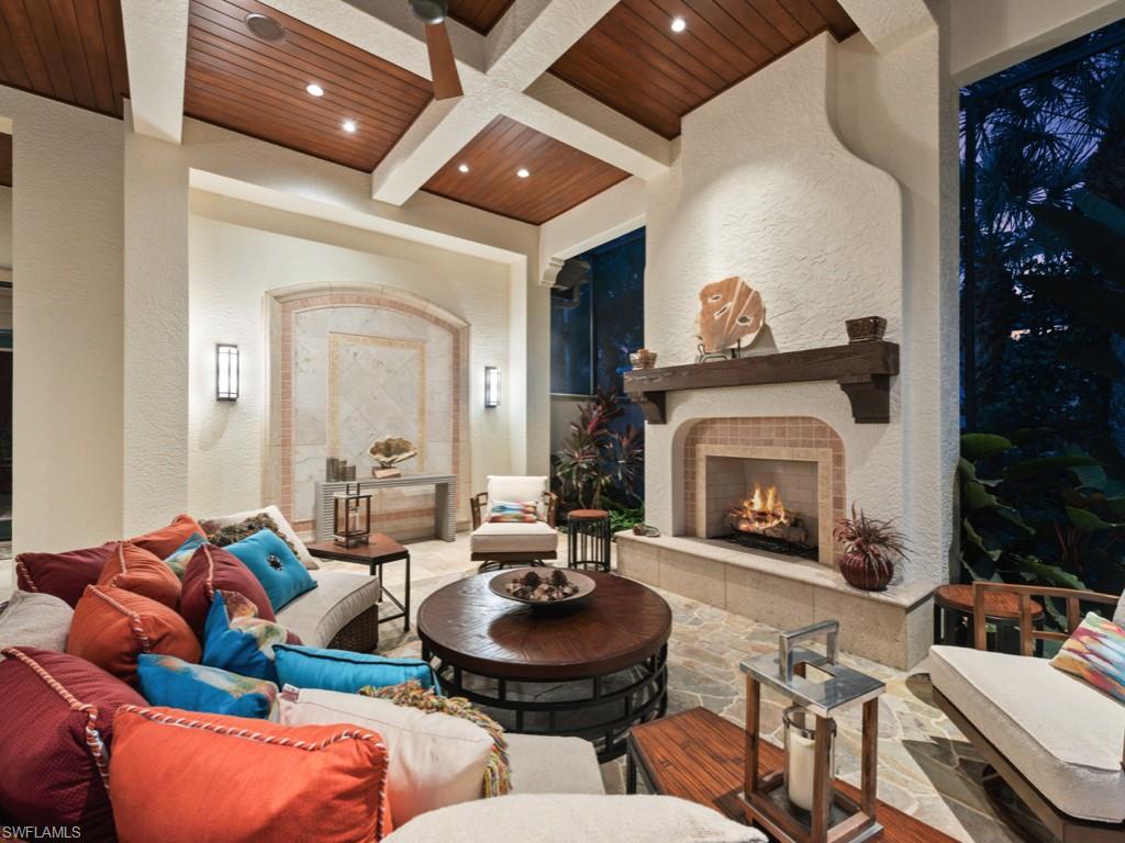 17012 Treviso Way Naples, FL 34110 - Photo 30 of 50 a living room with furniture and a fireplace