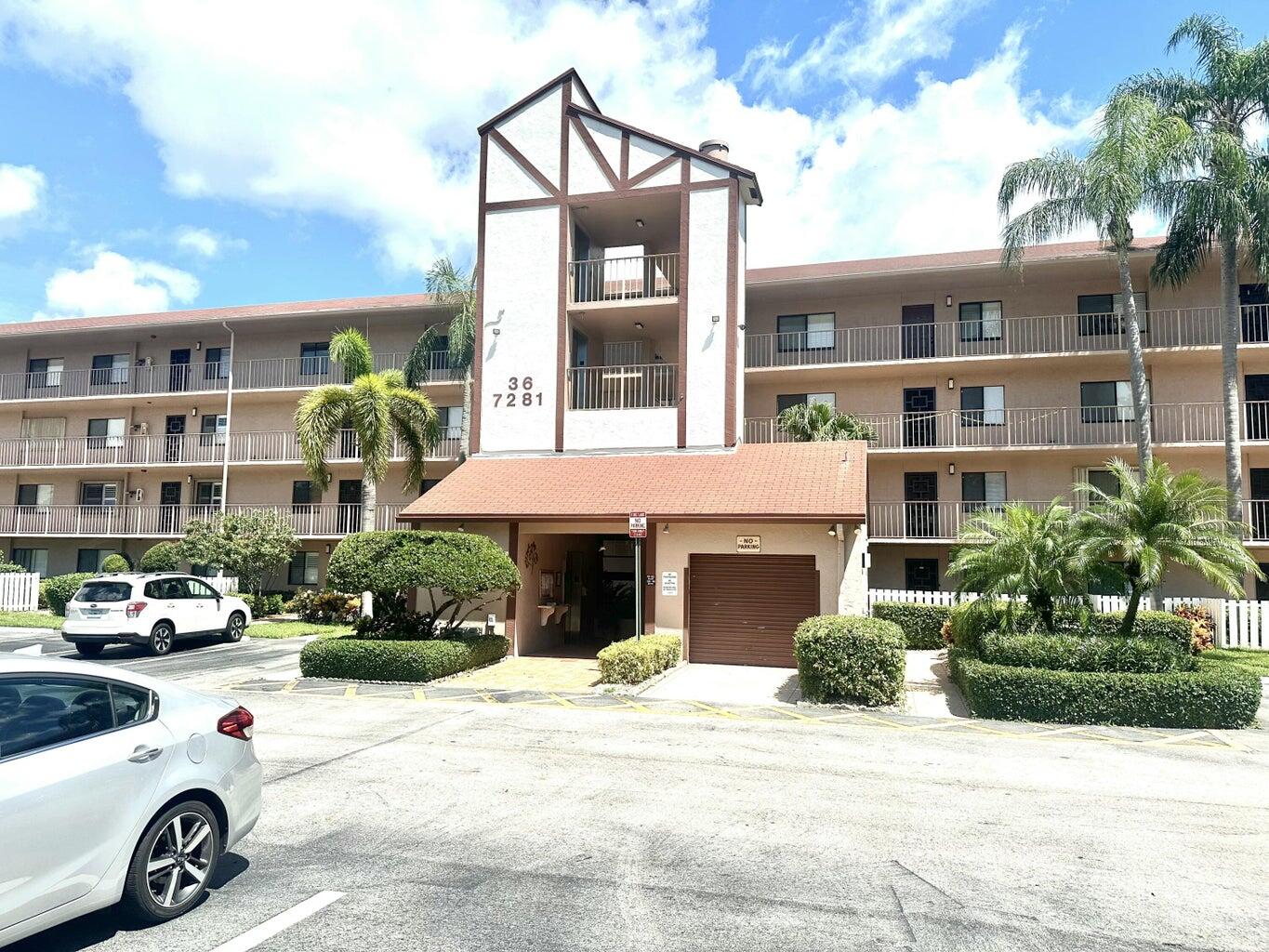 7281 Amberly Lane, Unit 308 Delray Beach, FL 33446 - Photo 1 of 20 a front view of a residential apartment building with a yard