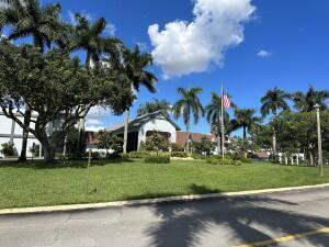 7281 Amberly Lane, Unit 308 Delray Beach, FL 33446 - Photo 11 of 20 a view of a white house with a big yard and palm trees