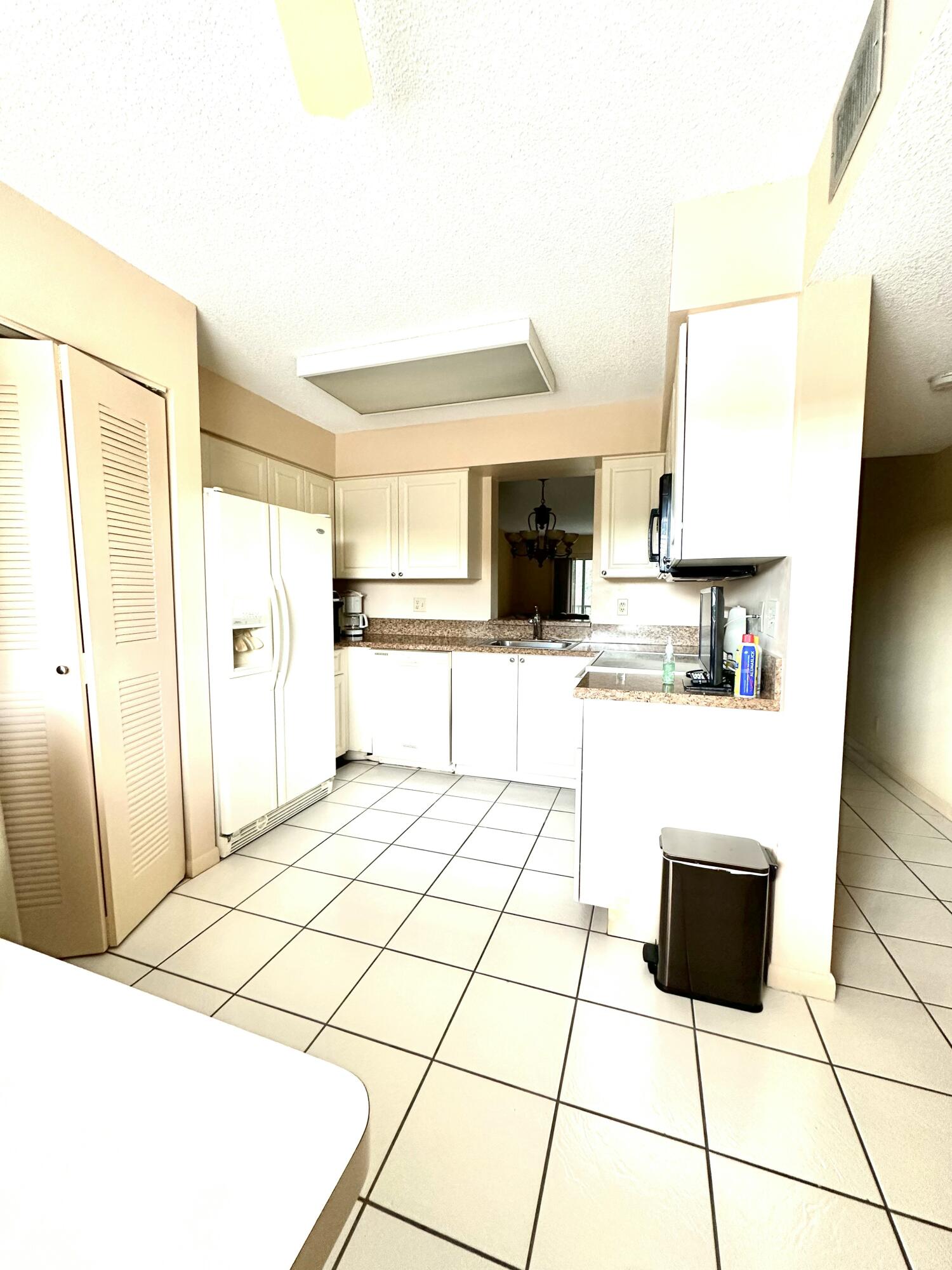 7281 Amberly Lane, Unit 308 Delray Beach, FL 33446 - Photo 2 of 20 a kitchen with stainless steel appliances kitchen island granite countertop a refrigerator and a stove top oven