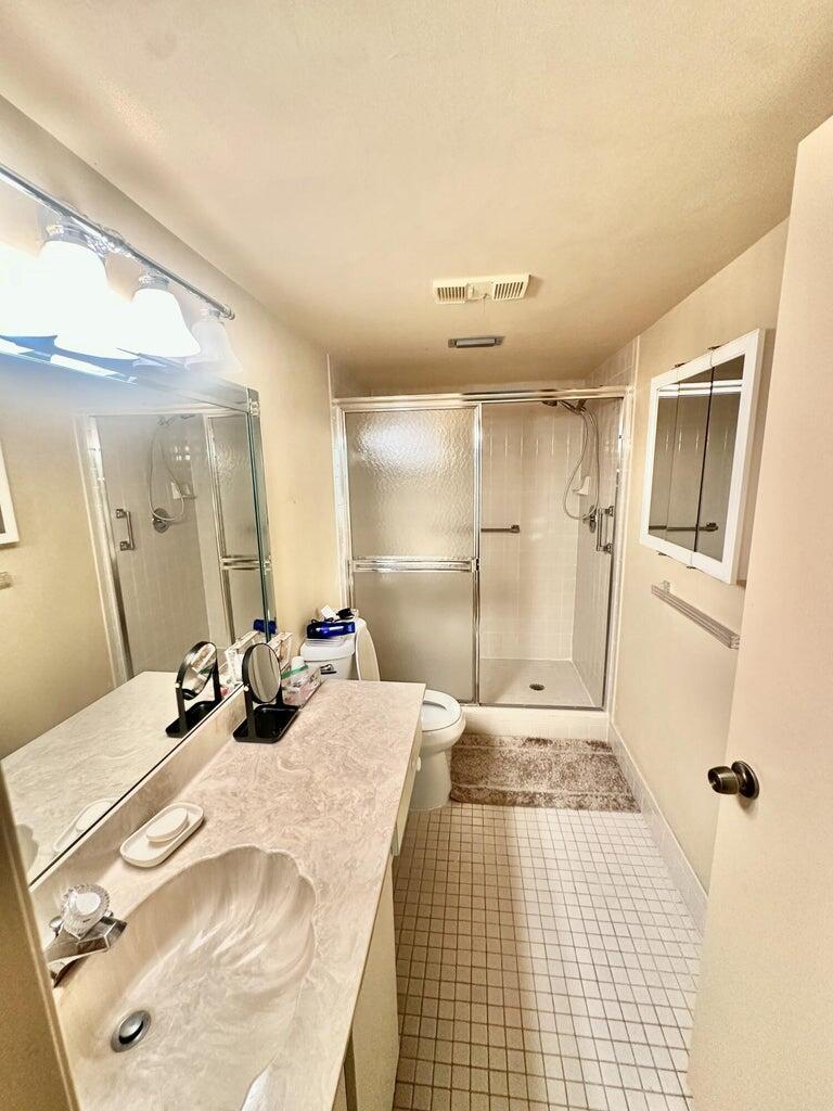 7281 Amberly Lane, Unit 308 Delray Beach, FL 33446 - Photo 6 of 20 a large bedroom with a bed and a mirror