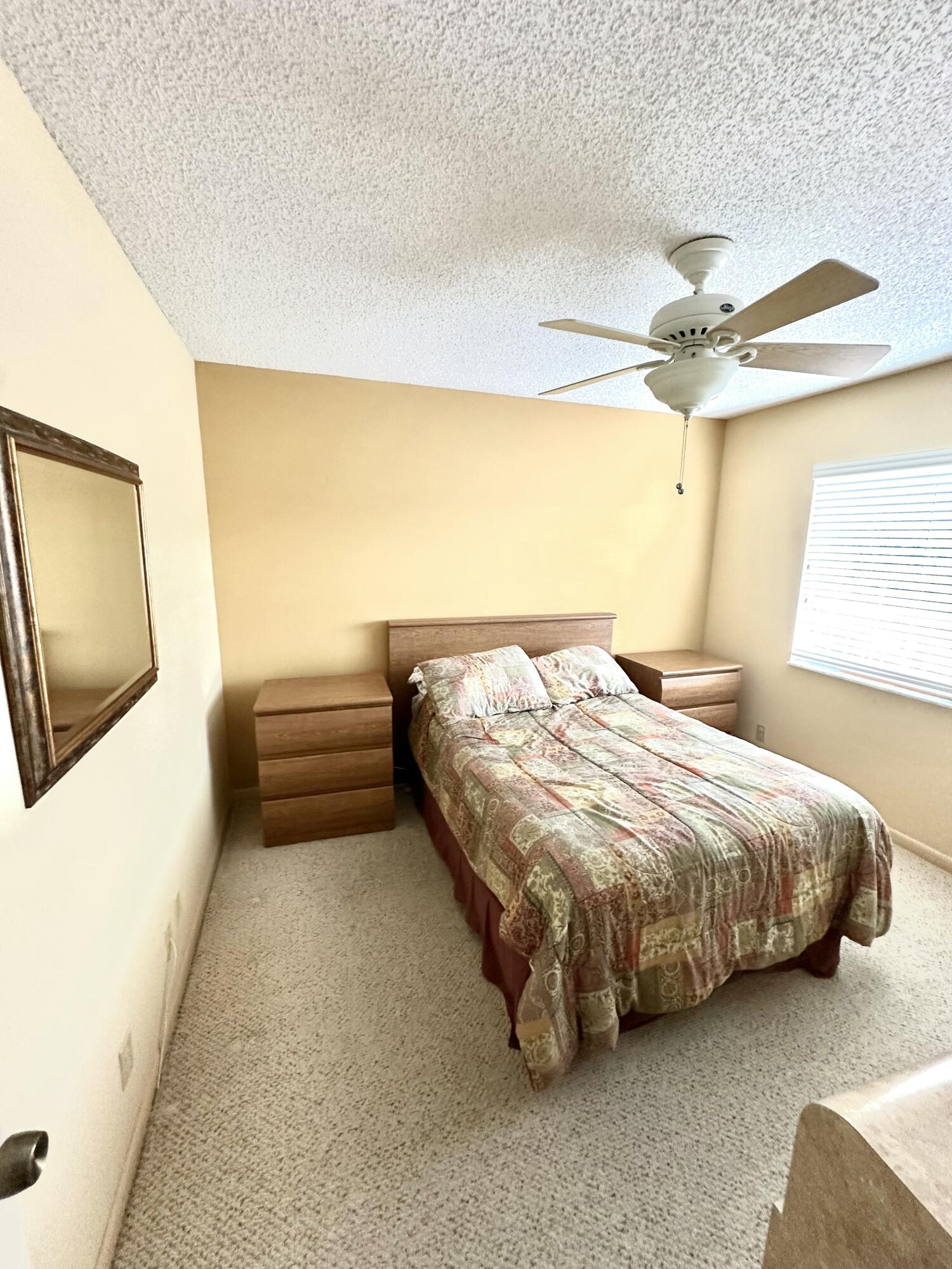 7281 Amberly Lane, Unit 308 Delray Beach, FL 33446 - Photo 8 of 20 a bedroom with a bed and a chandelier