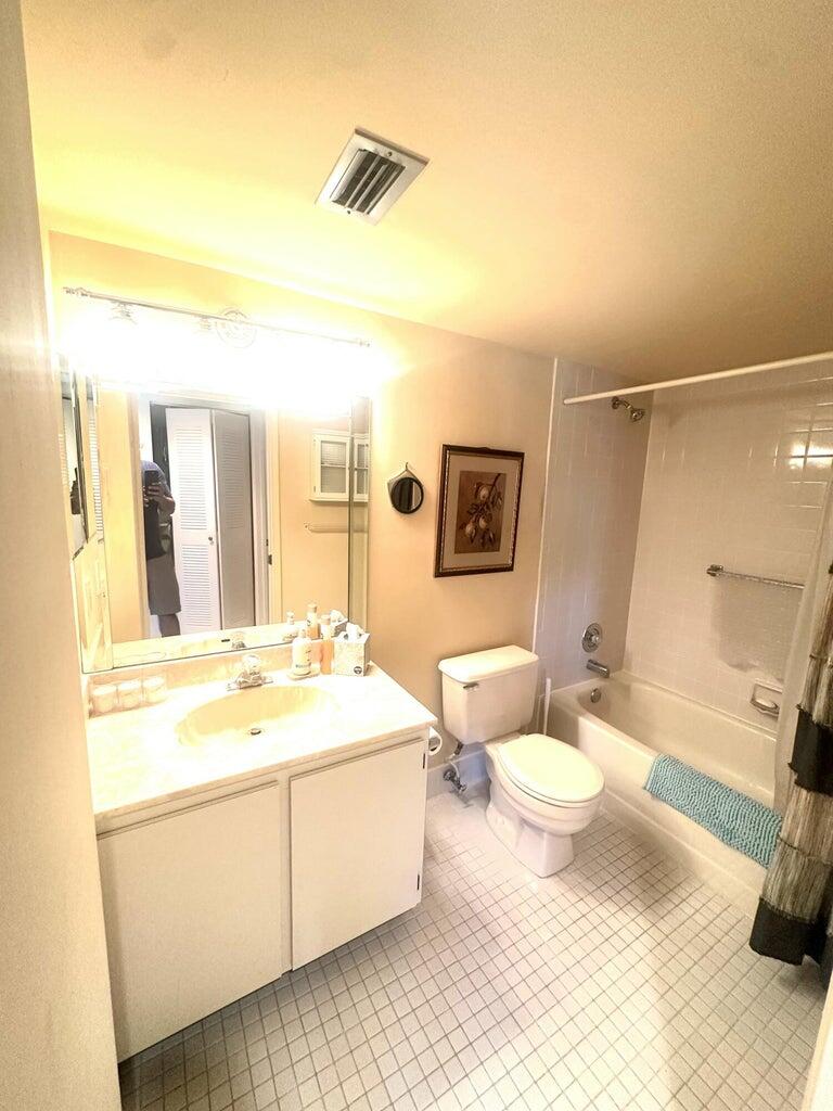 7281 Amberly Lane, Unit 308 Delray Beach, FL 33446 - Photo 9 of 20 a bathroom with a sink a toilet and a mirror