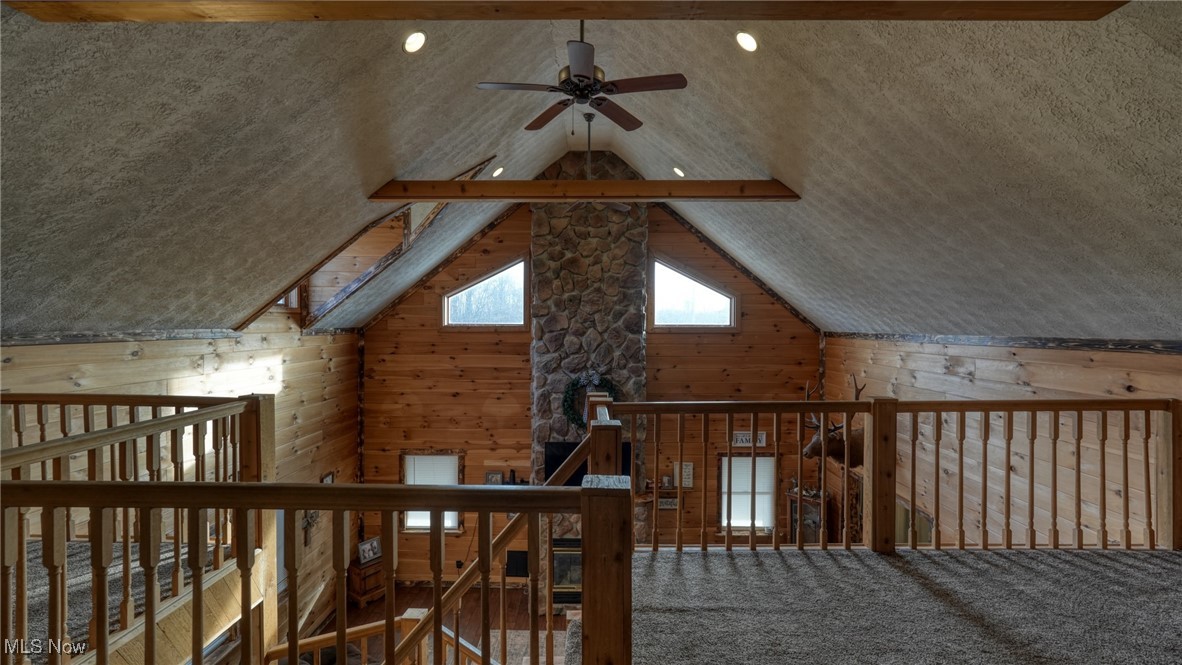 8498 Euga Road Newcomerstown, OH 43832 - Photo 26 of 49 Additional living space with ceiling fan, wooden walls, and vaulted ceiling