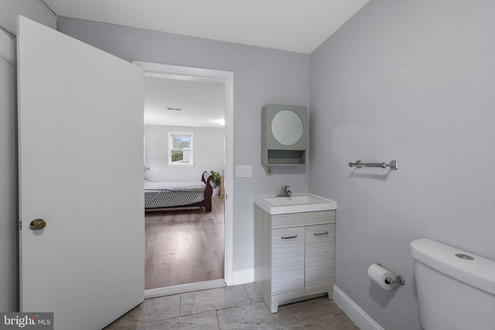 26001 Frederick Road Clarksburg, MD 20871 - Photo 19 of 46 a en suite bathroom with a toilet a sink and a mirror