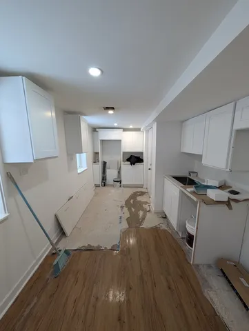 a kitchen with a sink and wooden floor