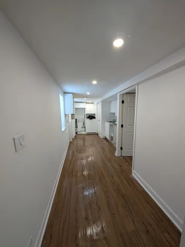 a big room with wooden floor and a window