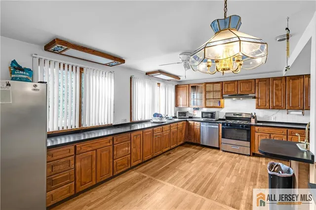 a large kitchen with stainless steel appliances granite countertop a stove and cabinets