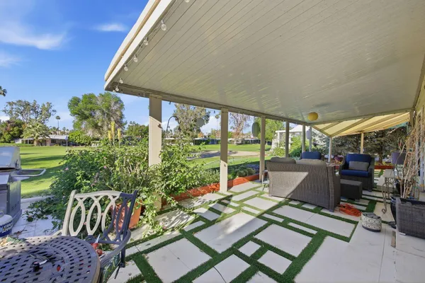 a view of backyard with outdoor seating and plants
