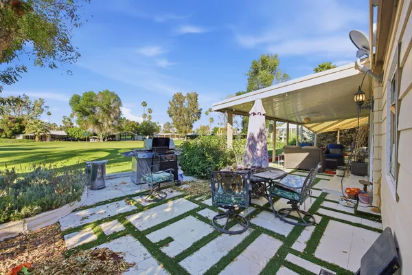 a view of a chairs and table in patio with a yard