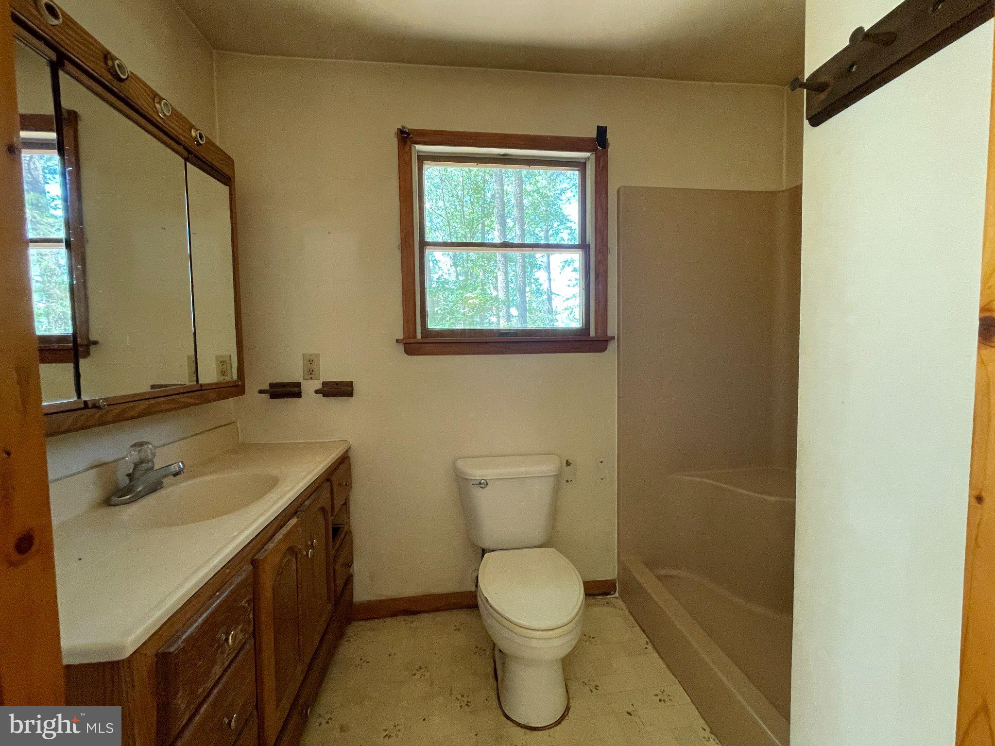 1113 Taylors Island Road Madison, MD 21648 - Photo 16 of 35 a bathroom with a granite countertop toilet sink and mirror