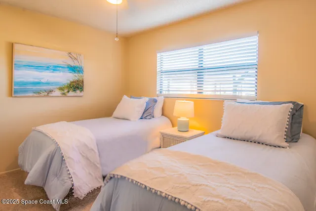 a bedroom with two beds and a large window