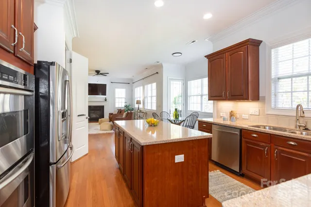 a kitchen with stainless steel appliances granite countertop a sink stove and refrigerator