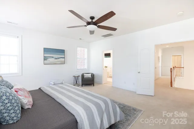 a bedroom with a large bed and a ceiling fan