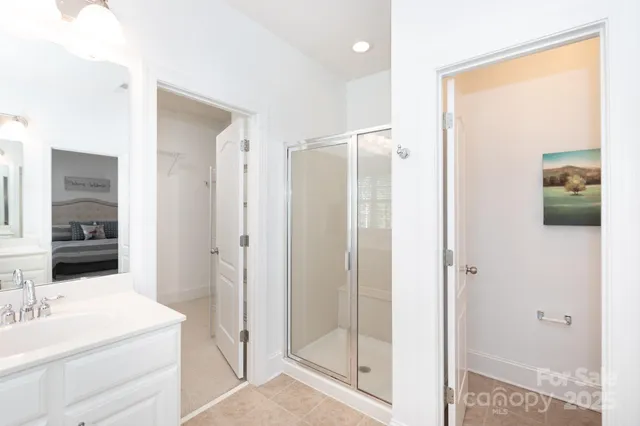 a en suite bathroom with a shower sink and mirror