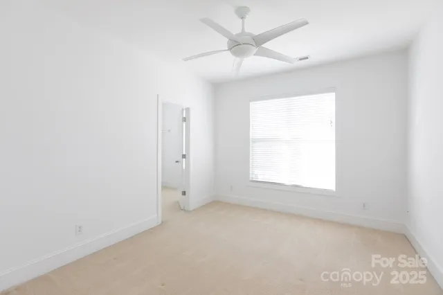 an empty room with a window and a fan