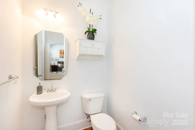 a bathroom with a sink mirror and toilet