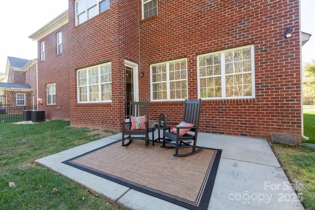 a view of a house with backyard and sitting area