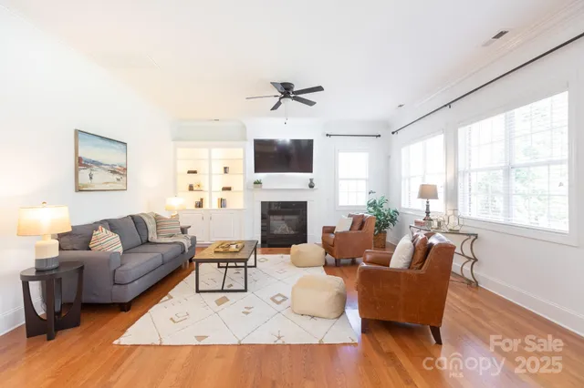 a living room with furniture a fireplace and a large window