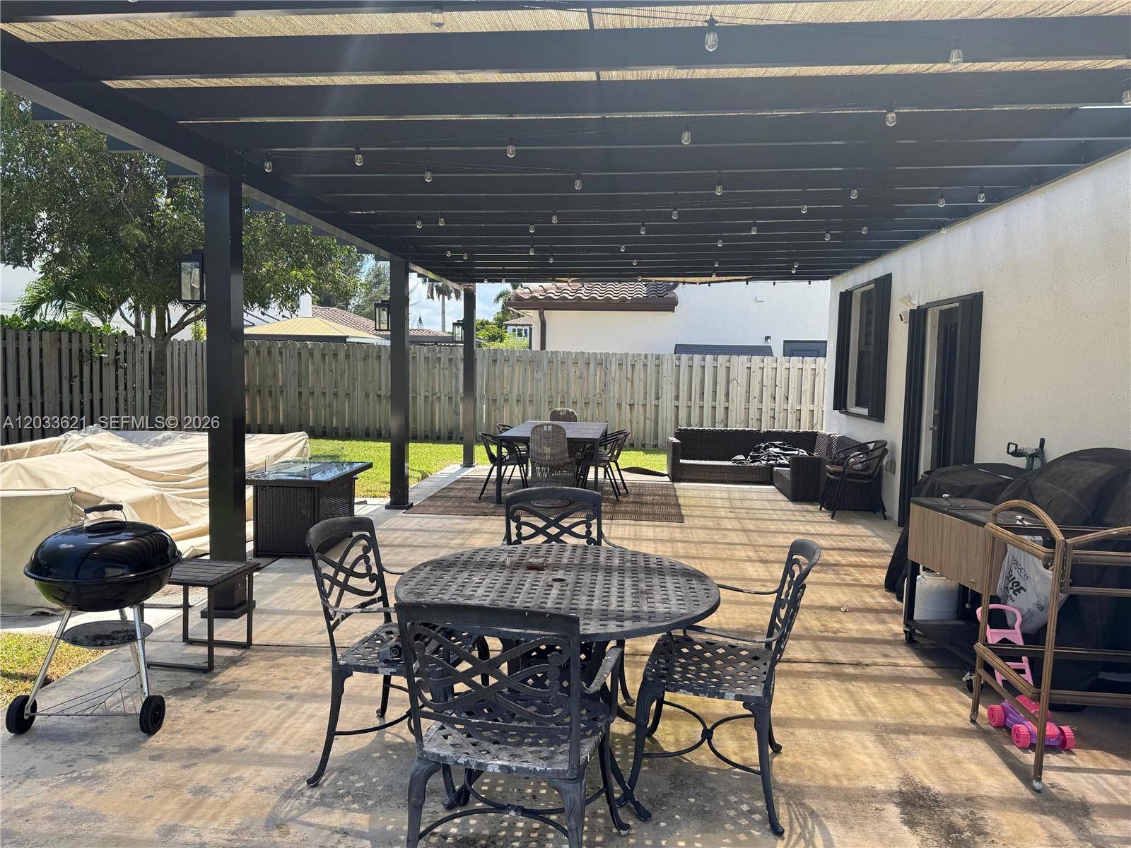 11942 Southwest 243rd Street Homestead, FL 33032 - Photo 38 of 50 a view of a patio with table and chairs potted plants with wooden floor and fence