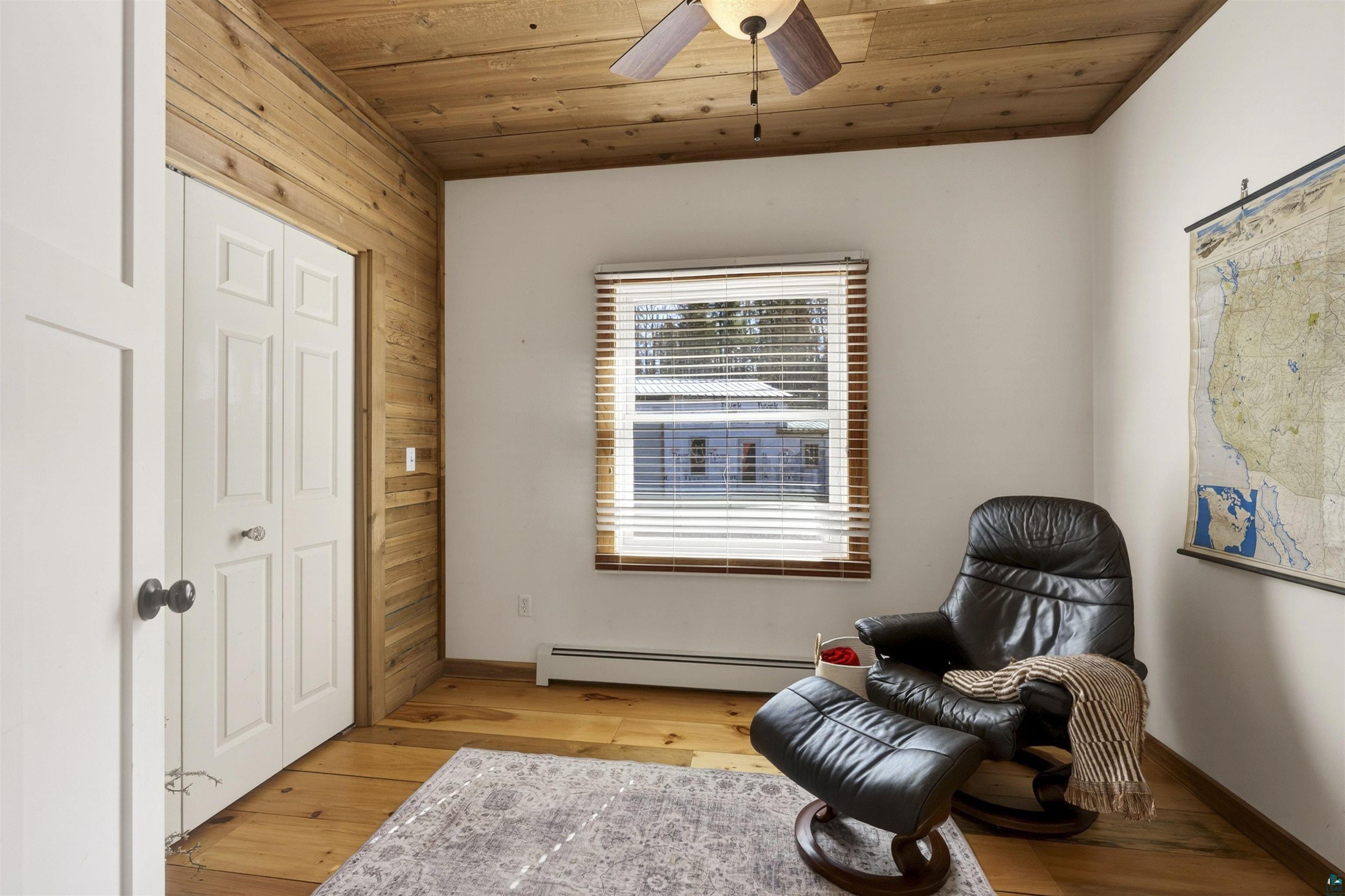 13885 Park Road Brule, WI 54820 - Photo 21 of 41 Natural wood-finish flooring complemented by a wood-paneled accent wall and ceiling