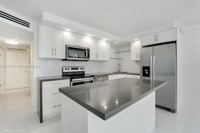 a kitchen with stainless steel appliances granite countertop a sink a stove and a refrigerator