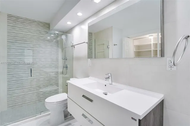 a bathroom with a toilet sink vanity and mirror