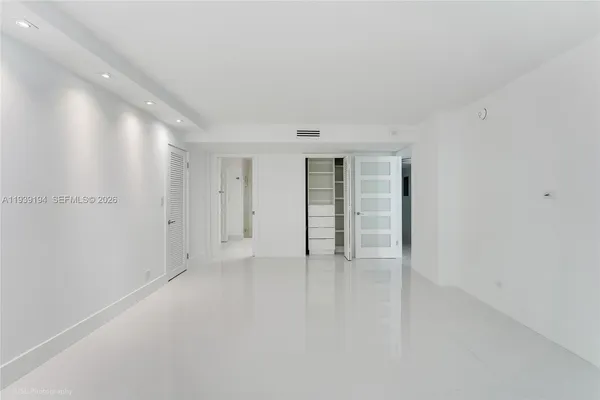 a view of an empty room with closet and a window