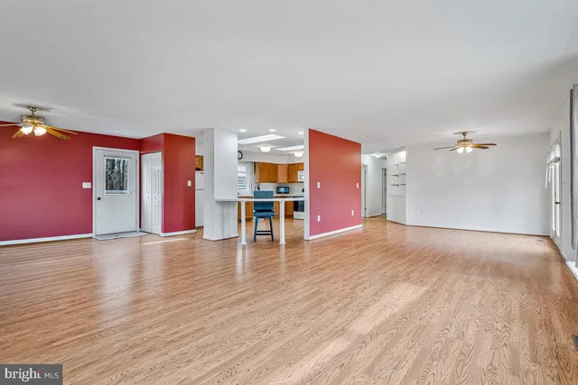 a front view of a house with a dirt yard and a large tree