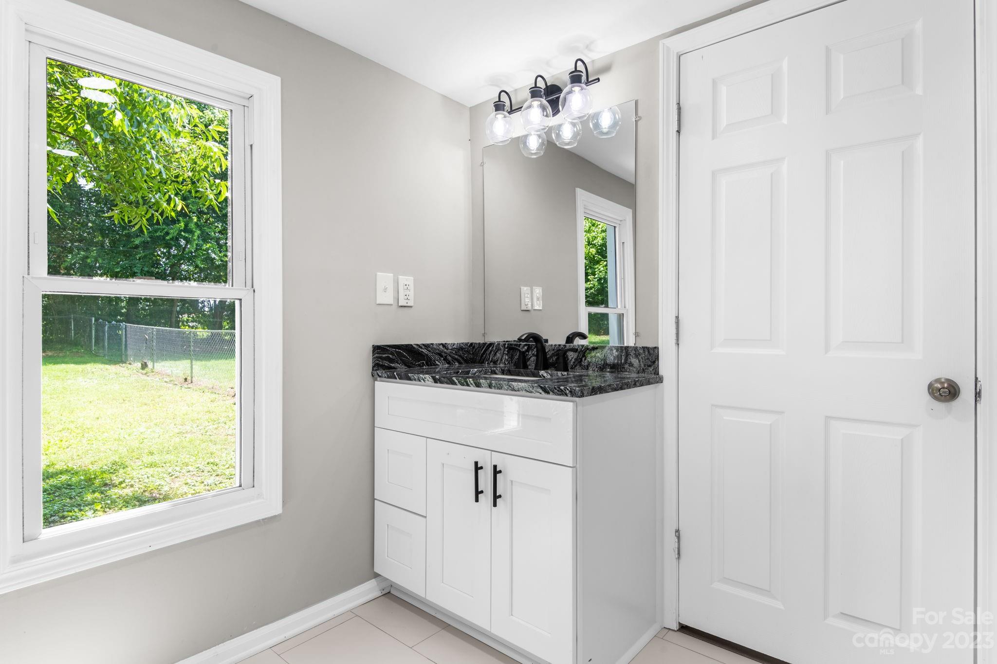60 Hunter Bridge Road Stony Point, NC 28678 - Photo 14 of 43 a bathroom with a granite countertop sink a vanity and a mirror