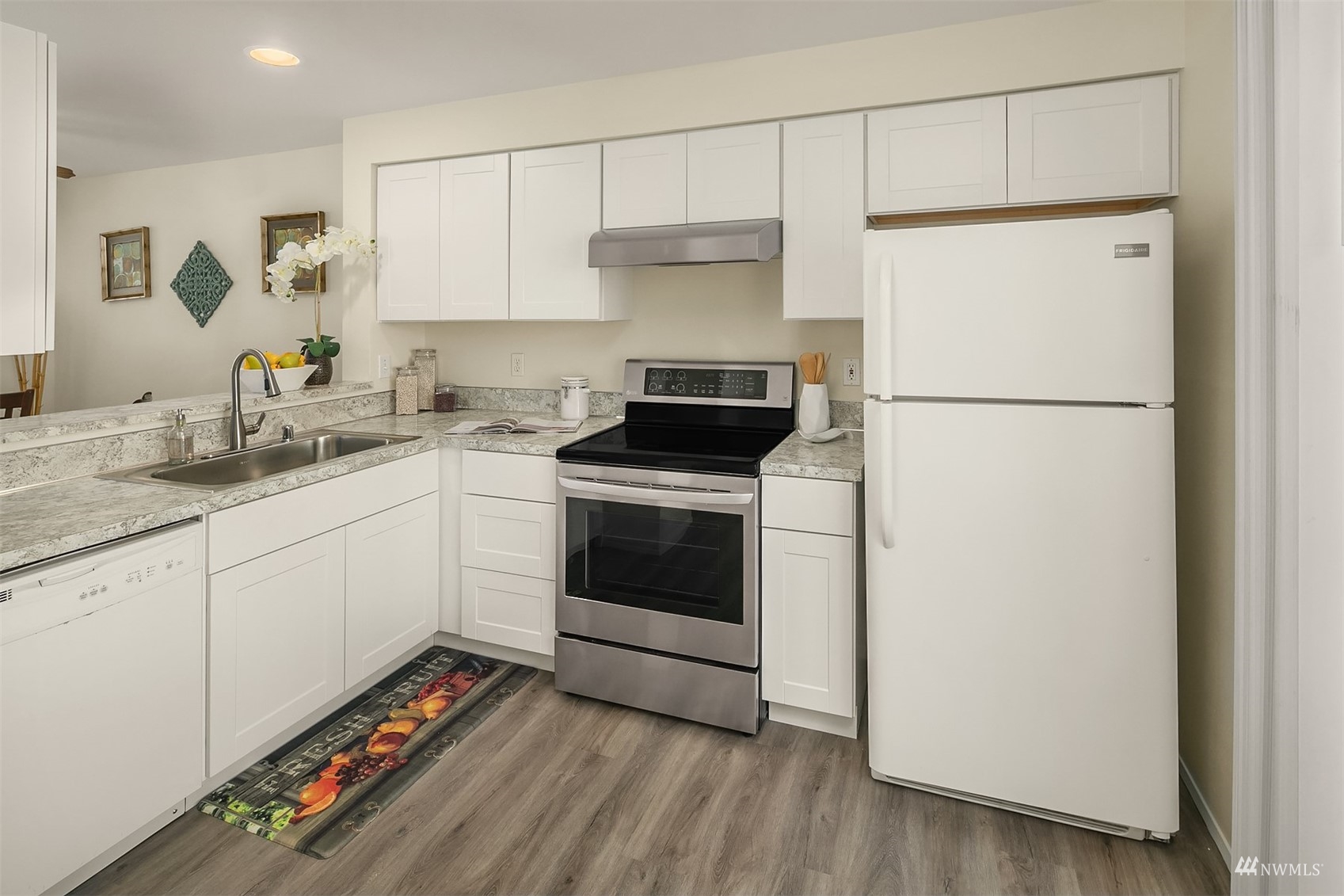 833 Southwest Sunset Boulevard, Unit G37 Renton, WA 98057 - Photo 3 of 21 a kitchen with a refrigerator sink and cabinets