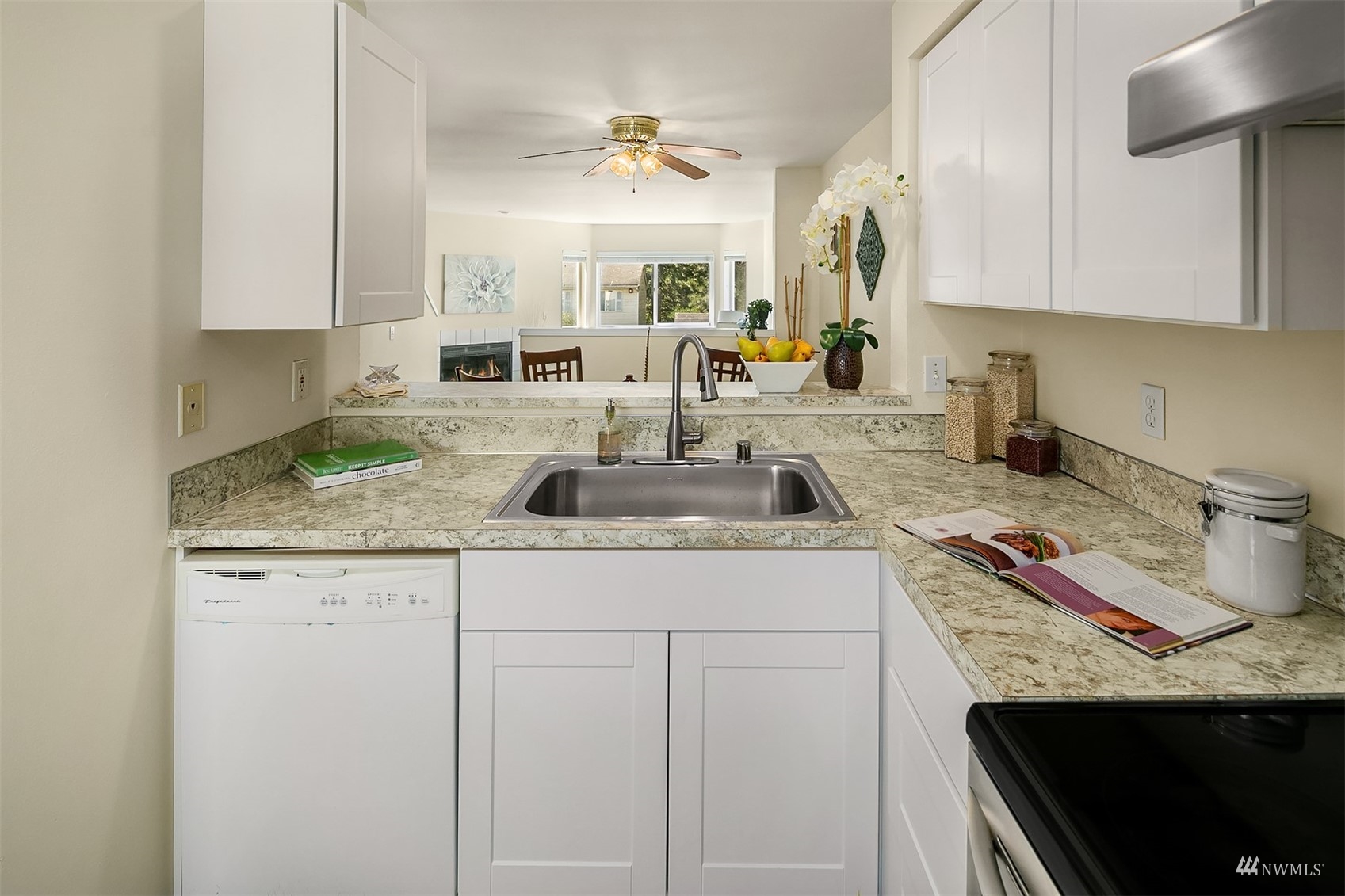 833 Southwest Sunset Boulevard, Unit G37 Renton, WA 98057 - Photo 4 of 21 a kitchen with granite countertop a sink stove and cabinets