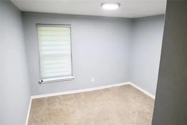 an empty room with a windows and exposed radiator