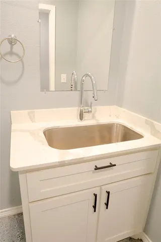 a white toilet sitting next to a bathroom sink and a white cabinet