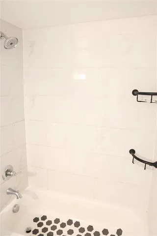 an empty room with a windows and exposed radiator